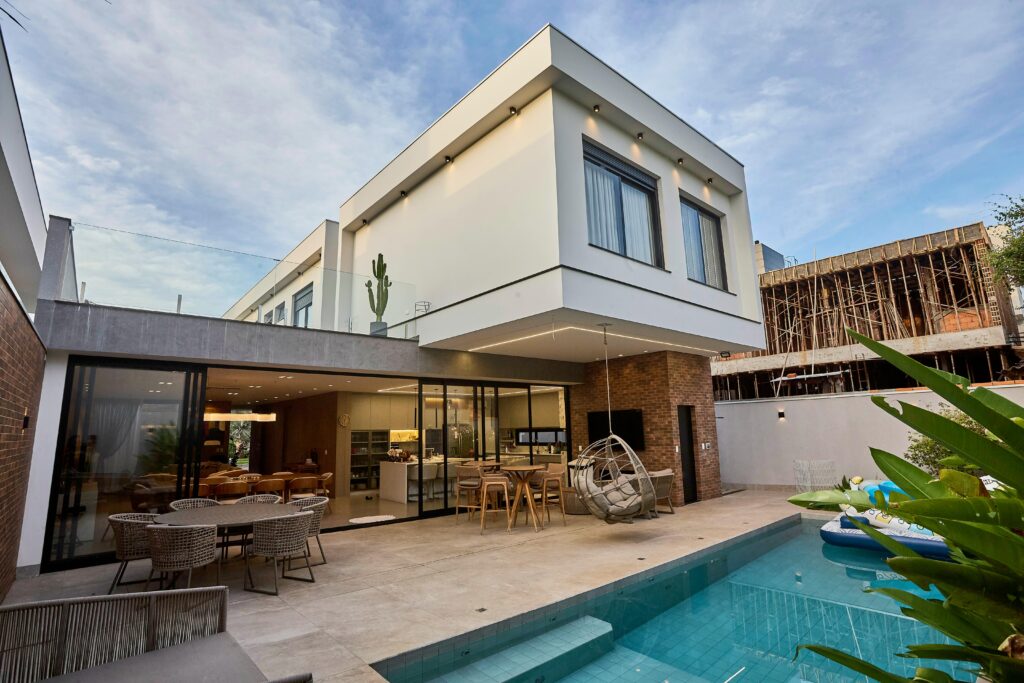 A contemporary luxury home with a pool and outdoor seating, showcasing modern architecture.