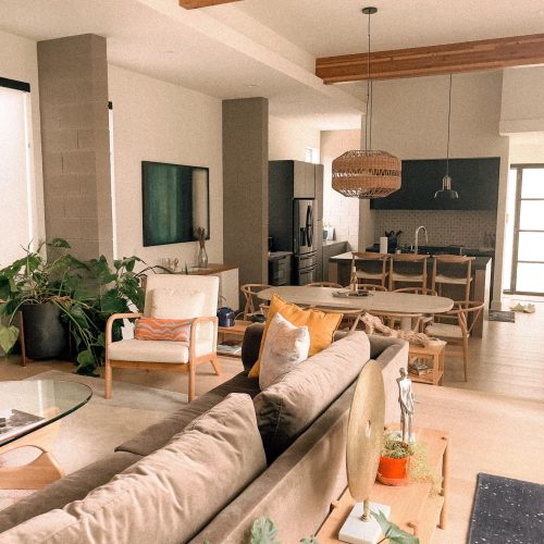 Bright modern living room with open kitchen, wood accents, and cozy decor.